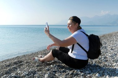 Mavi gökyüzü arka planında kırmızı ve beyaz ay ile Türk ulusal bayrağını sallayan, yakın plan