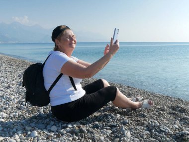 Mavi gökyüzü arka planında kırmızı ve beyaz ay ile Türk ulusal bayrağını sallayan, yakın plan