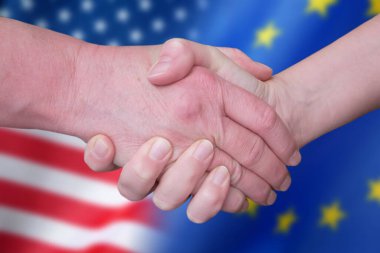 Handshake and European Union and United States flags, blue european union EU flag and half usa united states of america flag, concept, closeup