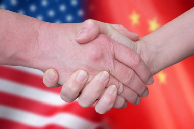 Handshake and China and United States flags, red with yellow stars Chinese flag and half usa united states of america flag, friendship and partnership between two counties, concept