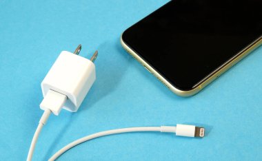 Using USB TYPE C Port Cable for mobile phone charger on blue background, charger cable, closeup