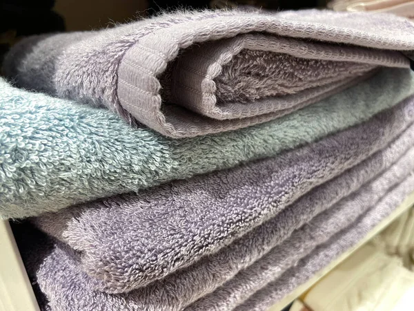 Towel shop, shelf of bed linens cupboard textile arrangement storage, closeup