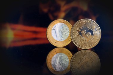 Bitcoin crypto currency and one euro coin burning under fire on black background, concept, closeup