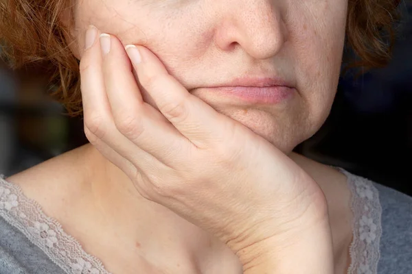 body language, a woman props her head with her hand - a symbol of boredom and lack of interest in the interlocutor, closeup