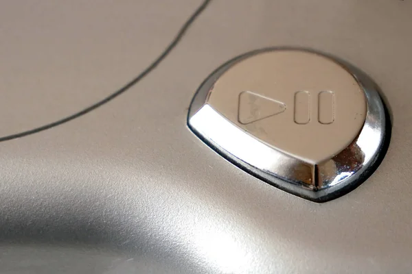 button with play symbol of vintage CD player, closeup