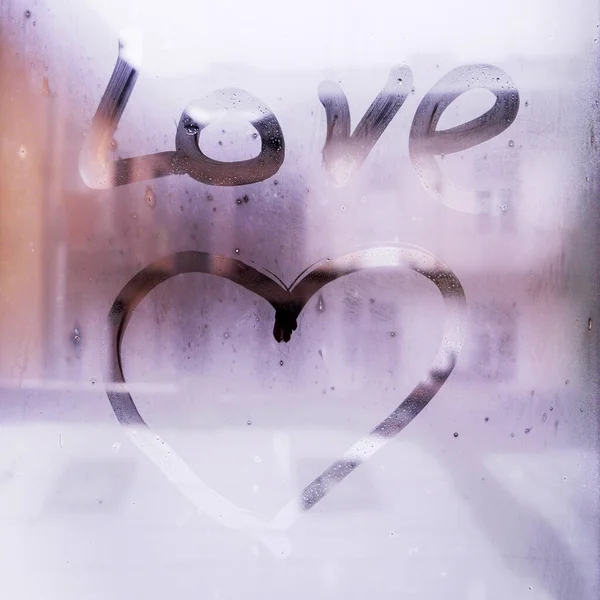 heart is painted on the misted glass of window in the winter time, concept