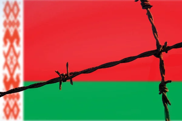 Republic of Belarus flag behind barbed wire fence. Concept of sanctions, embargo, dictatorship, discrimination and violation of human rights and freedom in Republic of Belarus. Closeup