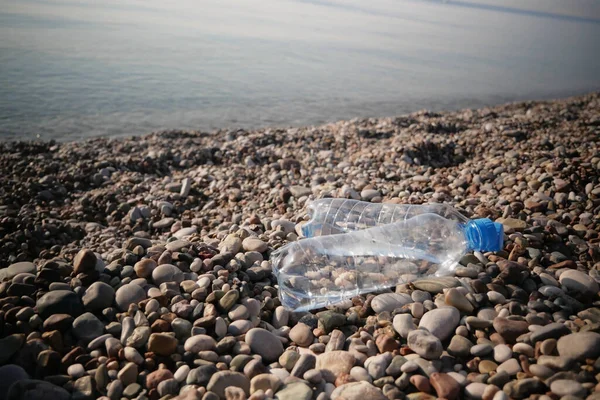 Plastic water bottles pollution in sea beach, dirty coast, beach pollution, closeup