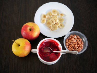 Muz, meyve jölesi, düşük kalorili süt tatlısı, koyu ahşap arka planda elmalar, sağlıklı kahvaltı, kolesterol karşıtı diyet, yakın plan.