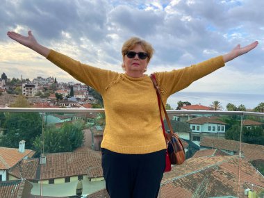 Son sınıf macerası, sırt çantalı ve eski Antalya Hindi 'sinde yürüyen yaşsız bir kadın. Emekliler için yaz turizmi. Açık havada.