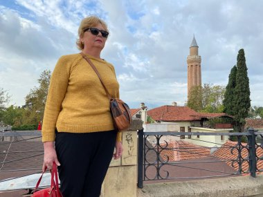 Son sınıf macerası, sırt çantalı ve eski Antalya Hindi 'sinde yürüyen yaşsız bir kadın. Emekliler için yaz turizmi. Açık havada.