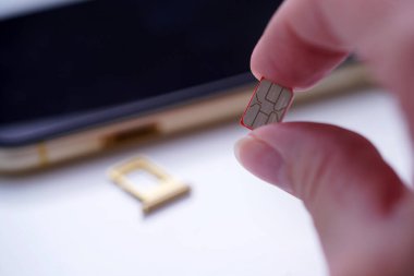 Cep telefonunun arkasına SIM kartı koyan kişi, telefona yerleştirilen Sim kartı, kapatma