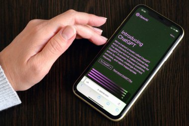 Lviv, Ukrayna - 03 11 2023: ChatGPT 'nin ticari sürümünü sunmak için OpenAI, arka planda Chat GPT giriş ekranı olan akıllı telefon görüntüsü. OpenAI 'den yeni bir Yapay Zeka sohbet robotu.