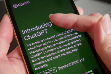 Lviv, Ukrayna - 03 11 2023: ChatGPT 'nin ticari sürümünü sunmak için OpenAI, arka planda Chat GPT giriş ekranı olan akıllı telefon görüntüsü. OpenAI 'den yeni bir Yapay Zeka sohbet robotu.