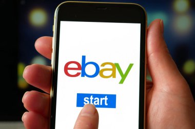 Lviv, Ukrayna - 03 11 2023: eBay uygulamasını akıllı telefonda kullanan kadın, İnternet alışveriş servisi eBay, yakın plan
