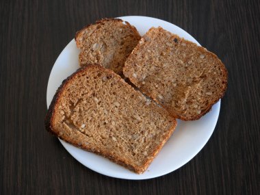 Tahta arka planda tam tahıllı ekmek, organik ev yapımı buğday ekmeği, yakın plan, makro