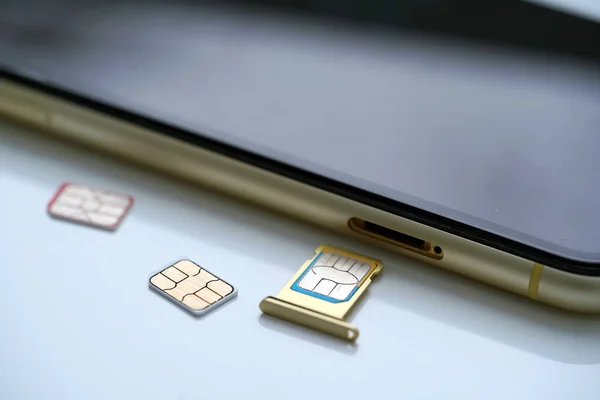 stock image Person holding a sim card into back of mobile phone, Sim card in tray being inserted into phone,