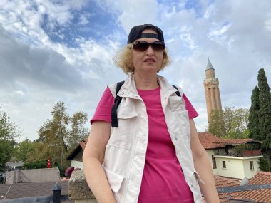 Sırt çantalı yaşlı kadın eski Antalya Hindi 'sinde yürüyor. Emekliler için yaz turizmi. Macera yaşsızdır, açık havada.