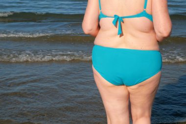 Ayrıca güneşli bir günde deniz sahilinde mayo giymiş yaşlı bir kadın dans ediyor. Tatil kavramında mutlu insanlar. Uluslararası Kadınlar Günü. Açık havada.