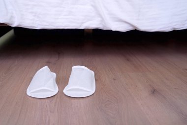 Beyaz rahat terlikler evdeki ya da oteldeki kanepenin yanında duruyor, kapalı, kapalı