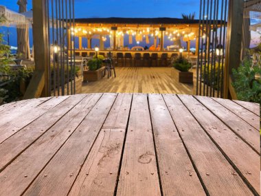 Bulanık içki tezgahı manzaralı ahşap masa. Ürününüzü sergilemek için boş masa. Kapalı alanda bulanık bir kafenin arka planında.