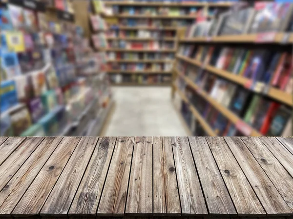 書店の背景にぼかし書棚と空の木製のテーブルの上 屋内の図書館の空のテーブル席 — ストック写真
