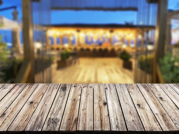 バーの背景がぼやけて見える木製のテーブル 製品を紹介するために空のテーブル ぼやけたカフェ黄金のボケの背景を背景に — ストック写真