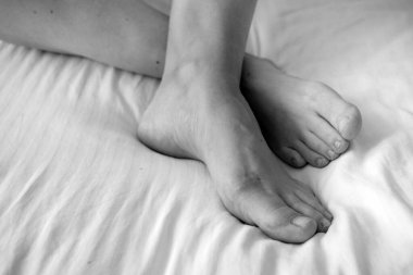 Kadın bacakları, kadın ayakları, ayak parmakları, çıplak ayaklar. Hallus valgus, siyah beyaz, yakın plan.