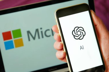 Lviv, Ukrayna - 03 11 2023: ekranda OPENAI logosu ve arka planda MICROFT logosu olan dizüstü bilgisayarlı akıllı telefon. Yakın çekim.