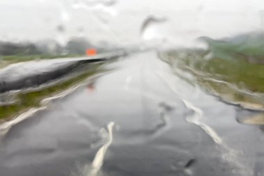 Otobanda yağmurlu bulanık görüntü, ön camda sağanak yağmur, otoyolda araba, kamyonet, tehlikeli sürüş koşulları, kötü hava, yakın çekim.