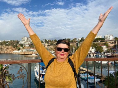 Son sınıf macerası, sırt çantalı ve eski Antalya Hindi 'sinde yürüyen yaşsız bir kadın. Emekliler için yaz turizmi. Açık havada.