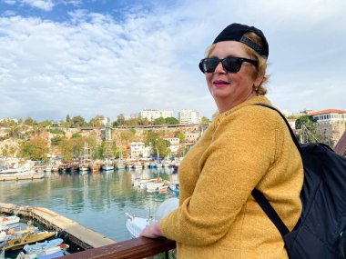 Son sınıf macerası, sırt çantalı ve eski Antalya Hindi 'sinde yürüyen yaşsız bir kadın. Emekliler için yaz turizmi. Açık havada.