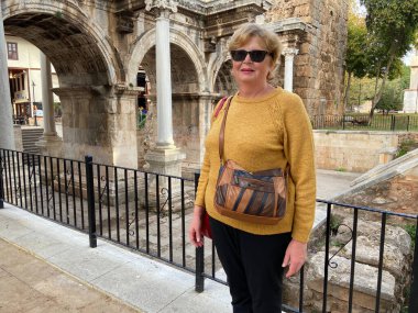 Son sınıf macerası, sırt çantalı ve eski Antalya Hindi 'sinde yürüyen yaşsız bir kadın. Emekliler için yaz turizmi. Açık havada.