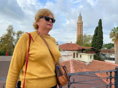 Son sınıf macerası, sırt çantalı ve eski Antalya Hindi 'sinde yürüyen yaşsız bir kadın. Emekliler için yaz turizmi. Açık havada.