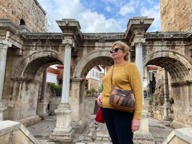 Son sınıf macerası, sırt çantalı ve eski Antalya Hindi 'sinde yürüyen yaşsız bir kadın. Emekliler için yaz turizmi. Açık havada.