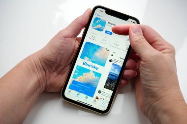 Lviv, Ukrayna - 09: 25 2023: iPhone ekranında bir Uygulama Mağazasında Twitter alternatif Bluesky Sosyal medya. Beyaz arkaplanda Bluesky uygulaması olan el ele tutuşma iPhone 'u, Bluesky merkezi olmayan bir sosyal ağ protokolü geliştirmek için bir girişimdir.