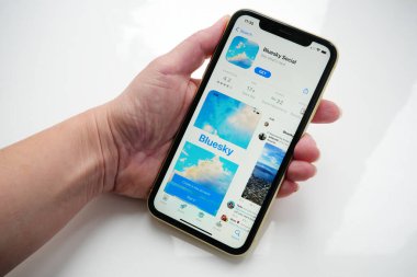 Lviv, Ukrayna - 09: 25 2023: iPhone ekranında bir Uygulama Mağazasında Twitter alternatif Bluesky Sosyal medya. Beyaz arkaplanda Bluesky uygulaması olan el ele tutuşma iPhone 'u, Bluesky merkezi olmayan bir sosyal ağ protokolü geliştirmek için bir girişimdir.