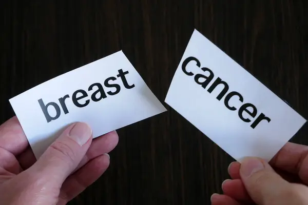 Hand Hålla Skärpapper Med Text Bröst Cancer Svart Trä Bakgrund — Stockfoto