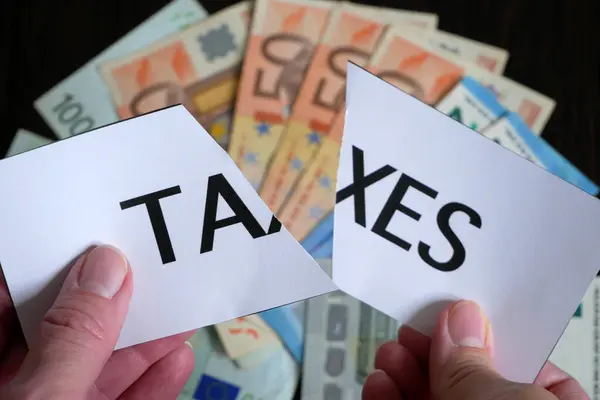 Нарезанная Бумага Надписью Налоги Лежит Поверх Большой Стопки Денег Евро — стоковое фото