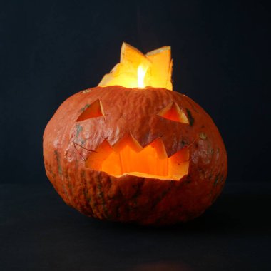 Komik Jack O Lantern Cadılar Bayramı balkabağı içinde mum ışığı olan siyah arka planda, yakın plan