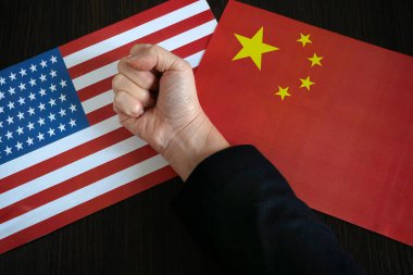 Çin ve ABD 'nin bayraklarının arka planına sıkışan parmaklar, iki ülke arasındaki çatışma, kavram, yakınlaşma