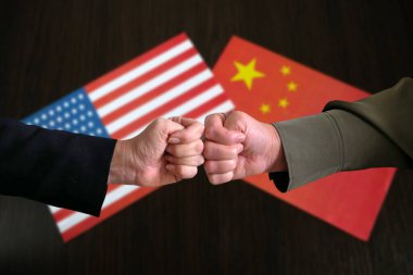 Çin ve ABD 'nin bayraklarının arka planına, iki ülke arasındaki çatışmaya, kavramlara, yakın çekime karşı yumruklara sımsıkı sarıldılar.