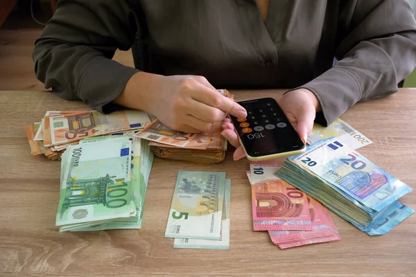 Hand Hält Einen Großen Stapel Eurogeld Auf Einem Holztisch Geld lizenzfreie Stockbilder