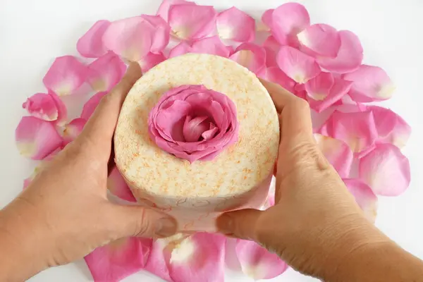 roll of toilet paper with fresh roses and petals on w background, gentle and soft toilet paper with rose fragrance