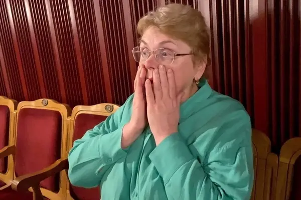woman surprised by events on theater stage, Senior woman is interested in watching ballet performance in theater hall,