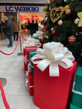 Ukrayna, Lviv - 25 Aralık 2022: Birçok dekorasyon ve hediye kutusuna sahip Noel ağacı ve alışveriş merkezindeki Cloth markası LC WAIKIKI mağazası, kış satışları konsepti, yeni yıl alışverişi, indoo