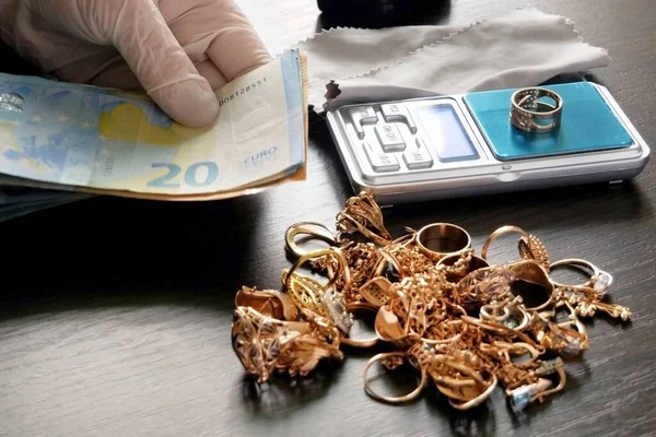 pawnshop worker counts money for gold jewelry on many golden and silver jewelleries background. Customers Buy and Sell Precious Metals, Jewels, Ancient Coins and Second Hand Appliances. Closeup