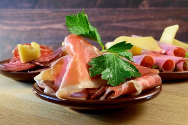 Soğuk Tütsülenmiş Et, Jambon, Sosis, Soğuk Et, Peynir. Tabak, antipasto, ahşap tabak. Dilimlenmiş jambonlu, jambonlu, jambonlu soğuk et tabağı. Yakın çekim.