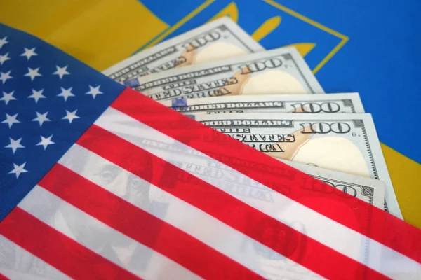 American and Ukrainian flags, a pack of American dollars. Support and help from USA to Ukraine in war with Russia. Save Ukraine, stop war concept