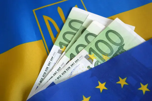 欧盟和乌克兰国旗和一堆欧元 欧盟支持和帮助乌克兰与俄罗斯交战 拯救乌克兰 停止战争概念 免版税图库图片